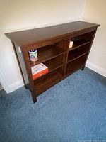 Front view of dark brown wood veneer TV stand with open shelving