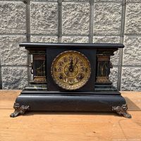 Full front view of black adamantine mantel clock