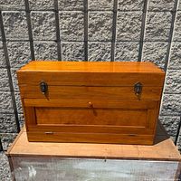 front view of closed wooden tool chest showing latches and drop-front panel