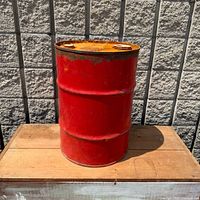 Full view of red steel drum on wooden surface