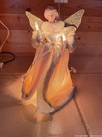 Angel tree topper illuminated, showing gown, wings and lights
