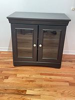 Front view of cabinet showing glass doors and knobs