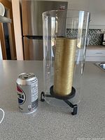 Holder with candle beside can for scale