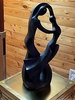 Front view of large black abstract figurative resin sculpture on chest