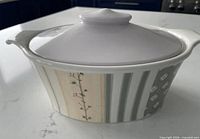 Oblique view of Portmeirion Dawn oval casserole with lid showing floral, stripe and geometric banding