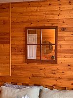 Full view of mirror on wood wall, four-pane design