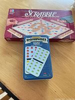 Closed Scrabble box and closed dominoes tin