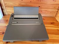 Front view with paper support raised showing keyboard and model marking