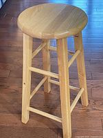 Full view of solid wood backless stool showing legs and stretchers