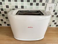 Front and side view of white Sunbeam 2-slice toaster on countertop
