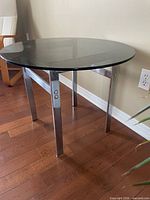 Side view of table showing chrome legs and smoked glass top