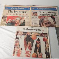Three championship front pages displayed: two standard broadsheets and one large-format cover
