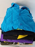 Stack of five folded shirts showing variety of colors