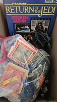 Sticker album and bagged toys in box