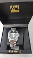 Watch in opened Mario Lopez presentation box showing dial and bracelet
