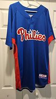 Full front view of blue Phillies jersey on hanger