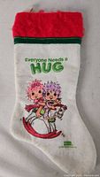 Front of white felt stocking showing Hugga Bunch graphic and text