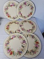 Six round floral placemats arranged face up