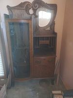 Full view of oak curio cabinet with secretary section