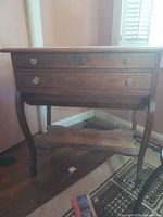 Full view of wooden nightstand showing two drawer fronts, lower shelf and curved legs