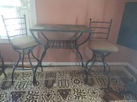 bar-height metal table with two matching stools