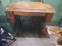 Front view of Singer treadle cabinet showing drawers and cast-iron base