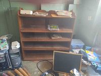 front view of wooden bookshelf showing shelves and carved top