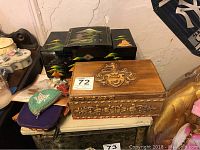 Assortment of wooden jewelry boxes and Native American-style beaded coin purses on table, showing carved wooden box and painted black lacquer box.