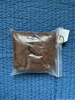 Sealed plastic bag containing brown alpaca roving fibres