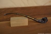 Full view of pipe showing brass stem and carved bowl