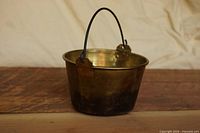 side view of brass kettle showing handle and exterior condition