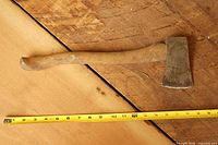 Hatchet lying flat with tape measure showing length