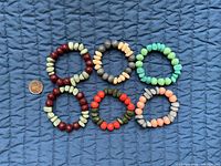 Six acrylic bead bracelets with coin for scale