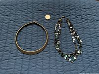 Both necklaces side by side with coin for scale