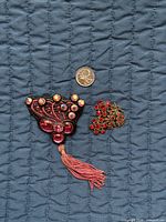 Front view of both jewellery pieces with coin for scale