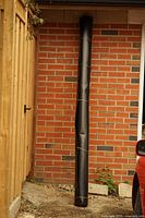 Full view of tall rolled mat leaning against brick wall
