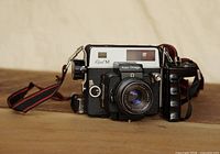 Front view of camera with lens, grip and strap attached