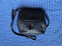 Front view showing flap, tassel, pebbled leather texture