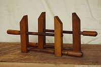 Both beech hand-screw clamps side view on wood surface
