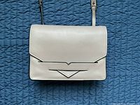Front view of mauve leather crossbody bag with strap displayed