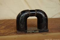 Front view of black U-shaped magnet on base
