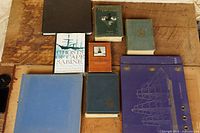Eight books and binder laid out on table