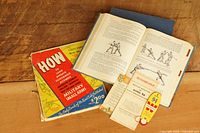All items laid out: open ROTC manual, closed volumes, small arms guide, two pamphlets