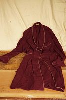 Full view of red wool housecoat with belt displayed flat