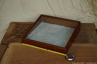 Top view of wooden display case showing glass lid and interior