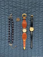Front view of both watches, bracelet, quarter for scale