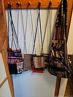 Five small woven pouches and one large woven backpack hanging; lot items are backpack and one pouch