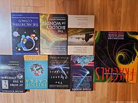 Group shot of nine paperback science books on wooden floor