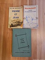 Front covers of all three books laid on wood floor