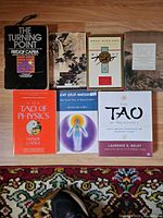 Six Taoism and Eastern philosophy books laid out on a rug and tabletop